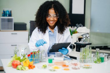 Gelişmiş teknoloji ve laboratuardaki hassas ekipmanları kullanarak sebzeleri güvenlik ve kalite için test edip analiz eden bir gıda bilimcisi.