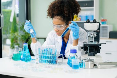 Modern tıbbi araştırma laboratuvarı. Kadın bilim adamı mikro pipetlerle çalışıyor biyokimyasal örnekleri analiz ediyor, tıp için ileri bilim kimya laboratuvarı. 