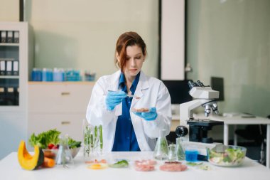 Laboratuvar bilimcileri olarak gıda bilimi, gelişmiş teknoloji ve hassas ekipmanlar kullanarak sebzeleri güvenlik ve kalite için test edip analiz ediyor. la içinde