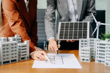 Çeşitli iş adamlarından oluşan bir ekip masanın yanında duruyor ve konut projesinin modelini tartışıyorlar. Yeşil iş şirketi ve Güneş Enerjisi Çevre Kenti Kavramı
