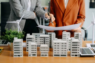 Çeşitli iş adamlarından oluşan bir ekip masanın yanında duruyor ve konut projesinin modelini tartışıyorlar. Yeşil iş şirketi ve Güneş Enerjisi Çevre Kenti Kavramı