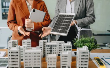 Çeşitli iş adamlarından oluşan bir ekip masanın yanında duruyor ve konut projesinin modelini tartışıyorlar. Yeşil iş şirketi ve Güneş Enerjisi Çevre Kenti Kavramı