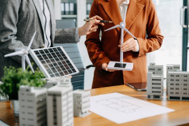 Çeşitli iş adamlarından oluşan bir ekip masanın yanında duruyor ve konut projesinin modelini tartışıyorlar. Yeşil iş şirketi ve Güneş Enerjisi Çevre Kenti Kavramı