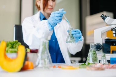 Laboratuvar bilimcileri olarak gıda bilimi, gelişmiş teknoloji ve hassas ekipmanlar kullanarak sebzeleri güvenlik ve kalite için test edip analiz ediyor. la içinde