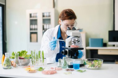 Modern bir laboratuvarda bilim adamı gelişmiş ekipmanlarla yiyecek örneklerini analiz ediyor. Gıda bilimi, gıda bilimi ve biyoteknoloji araştırmaları için mükemmel.