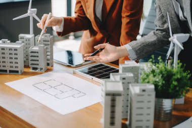 Çeşitli iş adamlarından oluşan bir ekip masanın yanında duruyor ve konut projesinin modelini tartışıyorlar. Yeşil iş şirketi ve Güneş Enerjisi Çevre Kenti Kavramı