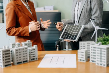 Çeşitli iş adamlarından oluşan bir ekip masanın yanında duruyor ve konut projesinin modelini tartışıyorlar. Yeşil iş şirketi ve Güneş Enerjisi Çevre Kenti Kavramı
