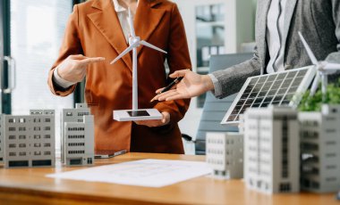 Çeşitli iş adamlarından oluşan bir ekip masanın yanında duruyor ve konut projesinin modelini tartışıyorlar. Yeşil iş şirketi ve Güneş Enerjisi Çevre Kenti Kavramı