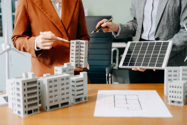 Çeşitli iş adamlarından oluşan bir ekip masanın yanında duruyor ve konut projesinin modelini tartışıyorlar. Yeşil iş şirketi ve Güneş Enerjisi Çevre Kenti Kavramı