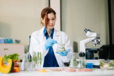 Laboratuvar bilimcileri olarak gıda bilimi, gelişmiş teknoloji ve hassas ekipmanlar kullanarak sebzeleri güvenlik ve kalite için test edip analiz ediyor. la içinde