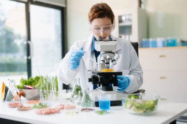 Modern bir laboratuvarda bilim adamı gelişmiş ekipmanlarla yiyecek örneklerini analiz ediyor. Gıda bilimi, gıda bilimi ve biyoteknoloji araştırmaları için mükemmel.