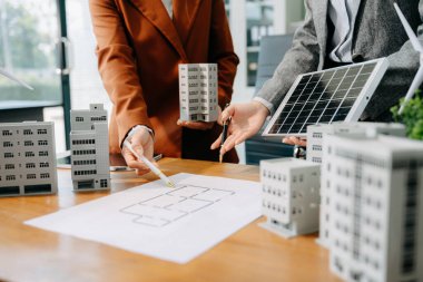 Çeşitli iş adamlarından oluşan bir ekip masanın yanında duruyor ve konut projesinin modelini tartışıyorlar. Yeşil iş şirketi ve Güneş Enerjisi Çevre Kenti Kavramı