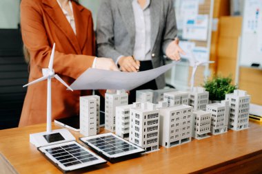 Çeşitli iş adamlarından oluşan bir ekip masanın yanında duruyor ve konut projesinin modelini tartışıyorlar. Yeşil iş şirketi ve Güneş Enerjisi Çevre Kenti Kavramı