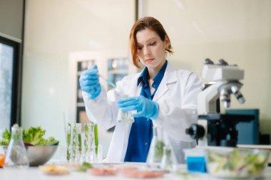 Laboratuvar bilimcileri olarak gıda bilimi, gelişmiş teknoloji ve hassas ekipmanlar kullanarak sebzeleri güvenlik ve kalite için test edip analiz ediyor. la içinde