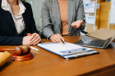 İş adamları masadaki dizüstü bilgisayarla kontrat belgelerini tartışıyor. 