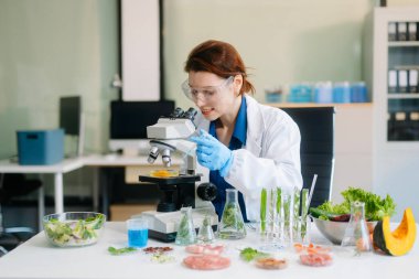 Modern bir laboratuvarda bilim adamı gelişmiş ekipmanlarla yiyecek örneklerini analiz ediyor. Gıda bilimi, gıda bilimi ve biyoteknoloji araştırmaları için mükemmel.