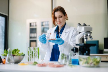 Laboratuvar bilimcileri olarak gıda bilimi, gelişmiş teknoloji ve hassas ekipmanlar kullanarak sebzeleri güvenlik ve kalite için test edip analiz ediyor. la içinde