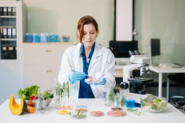 Laboratuvar bilimcileri olarak gıda bilimi, gelişmiş teknoloji ve hassas ekipmanlar kullanarak sebzeleri güvenlik ve kalite için test edip analiz ediyor. la içinde