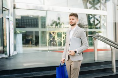 Yakışıklı, traşsız iş adamı. Şehir caddesinde dizüstü bilgisayarla, tabletle ve akıllı telefonla dolaşıyor.