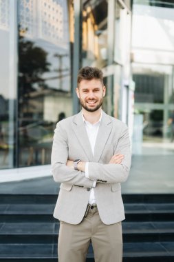 Başarılı iş adamı ofis yakınlarında çalışıyor. Güneş ışığında bir tablet ve akıllı telefon tutuyor.