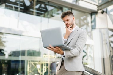 Yakışıklı, traşsız iş adamı. Şehir caddesinde dizüstü bilgisayarla, tabletle ve akıllı telefonla dolaşıyor.