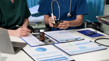 Doktorlar ve hemşireler modern bir tıp ofisinde işbirliği yapıyor, ekip çalışması ve hasta bakımını sergiliyorlar. Sağlık ve danışma konuları için mükemmel.