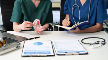 Diş hekimleri, çene örnekleriyle masaya oturur ve dişçi modern ofis profesyonel diş kliniğinde çalışırlar..