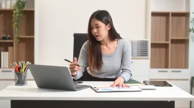 İş kadını ofis masasında dizüstü bilgisayar kullanıyor, vergi bildirimi yapıyor ve analitik araştırma yapıyor.