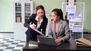 İş kadınlarının profesyonel tartışmaları, belgelere bakmaları ve ofiste dizüstü bilgisayar kullanmaları. İş takım çalışması başlangıç konsepti