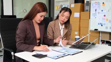 İş kadınları profesyonel tartışmalar yapıyorlar, belgelere bakıyorlar ve ofiste dizüstü bilgisayar ve dijital tablet kullanıyorlar. İş takım çalışması başlangıç konsepti