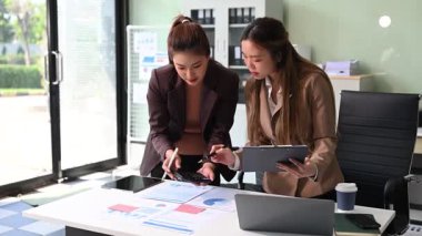 İş kadınları profesyonel tartışmalar yapıyorlar, belgelere bakıyorlar ve ofiste hesap makinesi ve dizüstü bilgisayar kullanıyorlar. İş takım çalışması başlangıç konsepti