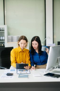 Modern ofiste birlikte çalışan iki genç iş kadınının portresi. İş takım çalışması başlangıç konsepti