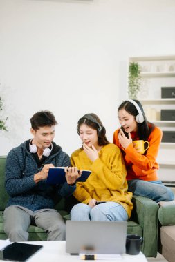 Gündelik giysiler içinde genç yetişkinlerden oluşan canlı bir grup, dizüstü bilgisayar ve kulaklık kullanıyorlar, takım çalışmasının, yaratıcılığın ve iç mekanda öğrenmenin tadını çıkarıyorlar. 