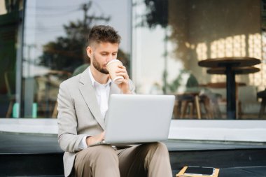 Modern iş adamı açık havada, tablet kullanıyor. İş, teknoloji ve yenilik temaları için idealdir. Kurumsal, profesyonel ve şehir yaşam tarzı kavramı