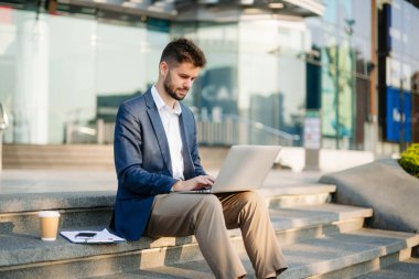 Modern iş adamı açık havada, tablet kullanıyor. İş, teknoloji ve yenilik temaları için idealdir. Kurumsal, profesyonel ve şehir yaşam tarzı kavramı