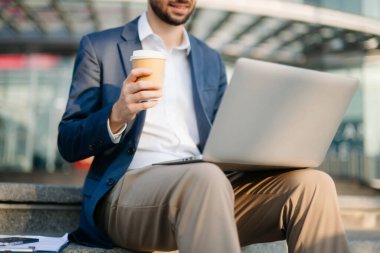 Modern iş adamı açık havada, tablet kullanıyor. İş, teknoloji ve yenilik temaları için idealdir. Kurumsal, profesyonel ve şehir yaşam tarzı kavramı