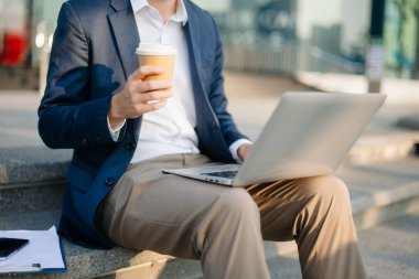 Modern iş adamı açık havada, tablet kullanıyor. İş, teknoloji ve yenilik temaları için idealdir. Kurumsal, profesyonel ve şehir yaşam tarzı kavramı