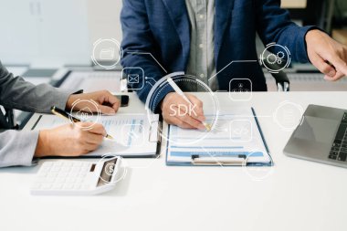 SDK Yazılım Geliştirme Kiti programlama dili teknolojisi konsepti, sanal ekranda SDK simgesiyle dizüstü bilgisayar ve tablet yazan kişi. Ofislerde