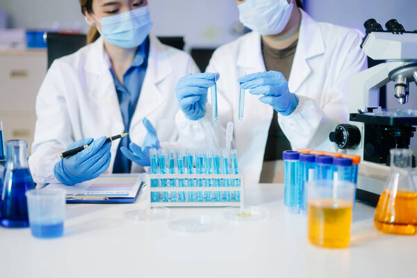 Young scientists conducting research investigations in a medical laboratory, using a microscope in laboratory for medicine.  