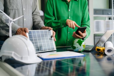 Mühendisler güneş ve rüzgar enerjisi, sürdürülebilirlik, yenilik ve temiz teknolojik çözümler üzerinde işbirliği yaparlar. Takım çalışması, yeşil güç ve gelecek vizyonu..
