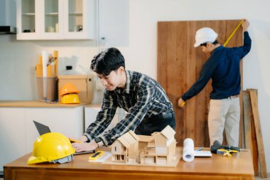 Mimarlar ve mühendisler bir mimari ofiste dizüstü bilgisayar kullanarak bir yapı modeli tasarlayarak, planlayarak ve yaratıcılıkla işbirliği yaparlar. 