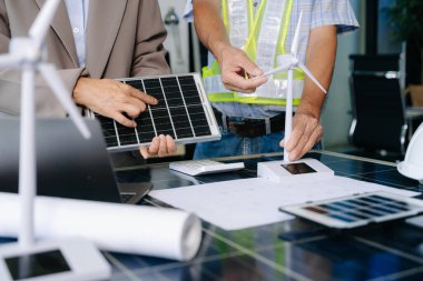İki mühendis güneş ve rüzgar enerjisi üzerinde işbirliği yaparak, temiz yenilik ve sürdürülebilirlik sağlıyorlar. Takım çalışması, teknoloji ve daha yeşil bir gelecek vizyonu..