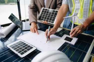 İki mühendis güneş ve rüzgar enerjisi üzerinde işbirliği yaparak, temiz yenilik ve sürdürülebilirlik sağlıyorlar. Takım çalışması, teknoloji ve daha yeşil bir gelecek vizyonu..