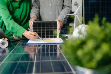 Mühendisler güneş ve rüzgar enerjisi, sürdürülebilirlik, yenilik ve temiz teknolojik çözümler üzerinde işbirliği yaparlar. Takım çalışması, yeşil güç ve gelecek vizyonu..