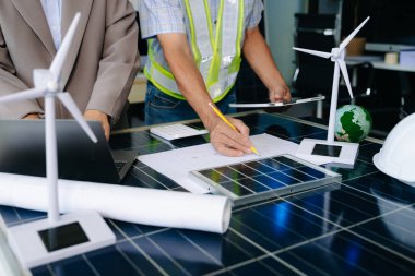 İki mühendis güneş ve rüzgar enerjisi üzerinde işbirliği yaparak, temiz yenilik ve sürdürülebilirlik sağlıyorlar. Takım çalışması, teknoloji ve daha yeşil bir gelecek vizyonu..