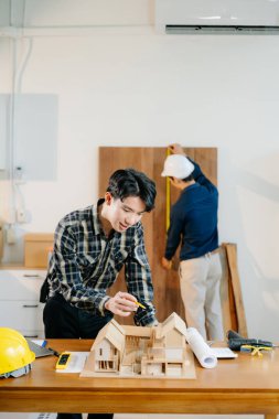 Mimarlar ve mühendisler bir mimarlık ofisinde bir yapı modeli, tasarım, planlama ve yaratıcılık üzerinde işbirliği yaparlar.