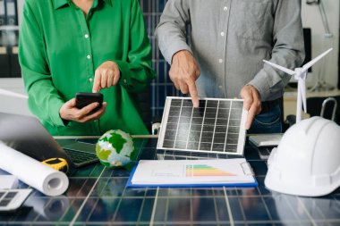 Mühendisler güneş ve rüzgar enerjisi, sürdürülebilirlik, yenilik ve temiz teknolojik çözümler üzerinde işbirliği yaparlar. Takım çalışması, yeşil güç ve gelecek vizyonu..
