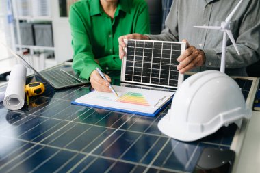 İki mühendis güneş ve rüzgar enerjisi üzerinde işbirliği yaparak, temiz yenilik ve sürdürülebilirlik sağlıyorlar. Takım çalışması, teknoloji ve daha yeşil bir gelecek vizyonu..