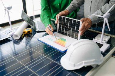 Mühendisler güneş ve rüzgar enerjisi, sürdürülebilirlik, yenilik ve temiz teknolojik çözümler üzerinde işbirliği yaparlar. Takım çalışması, yeşil güç ve gelecek vizyonu..