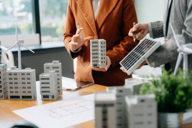 Mimarlar, tasarımcılar ve geliştiricilerin modern ofis toplantısı, inşa modelleri ve dijital araçlar kullanarak yenilikçi, sürdürülebilir konut projeleri yaratıyor.